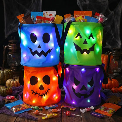 Four glowing LED candy buckets filled with Halloween candy on a wooden table