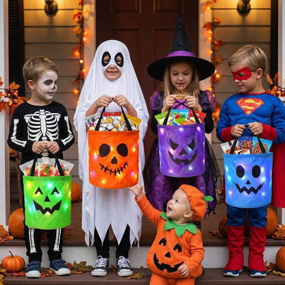 Kids in costume trick-or-treating with light-up jack-o'-lantern candy buckets