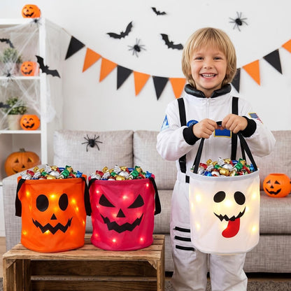 Boy in an astronaut costume holding a white ghost LED candy bucket