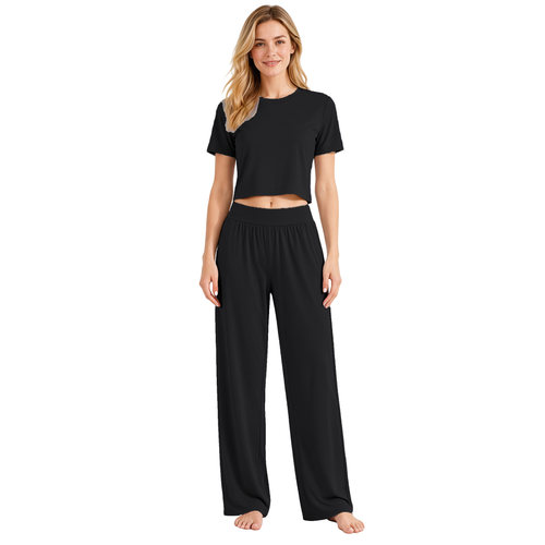Black colourway — AI-generated studio image of an adult model wearing the two-piece pyjama set (short cropped crew-neck tee with exposed midriff, wide elastic high-waist wide-leg trousers)
